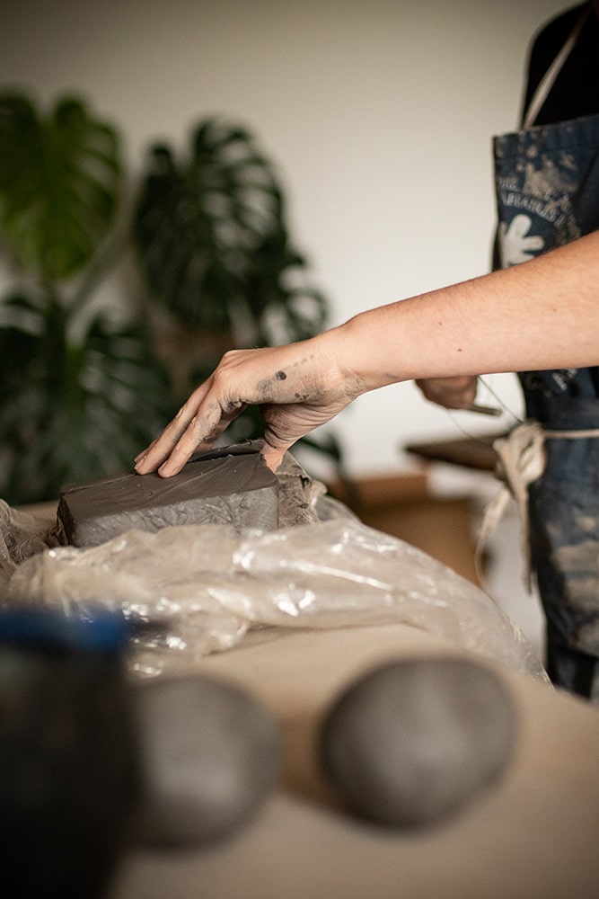 Division et découpe de la terre pour la confection de pièces en céramique artisanales réalisées par Manon Renault, céramiste près de Doué en Anjou et Saumur photographié dans son atelier par Margot Vincent alias Margotine Photographies, photographe près d'Angers