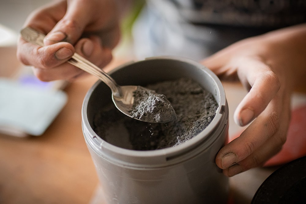 Essai et recherche de recette avec de la poudre d'ardoise et de la cendre pour la confection d'un émail artisanal et naturel pour la céramique réalisé par Manon Renault, céramiste près de Doué en Anjou et Saumur photographié dans son atelier par Margot Vincent alias Margotine Photographies, photographe près d'Angers dans le maine-et-loire