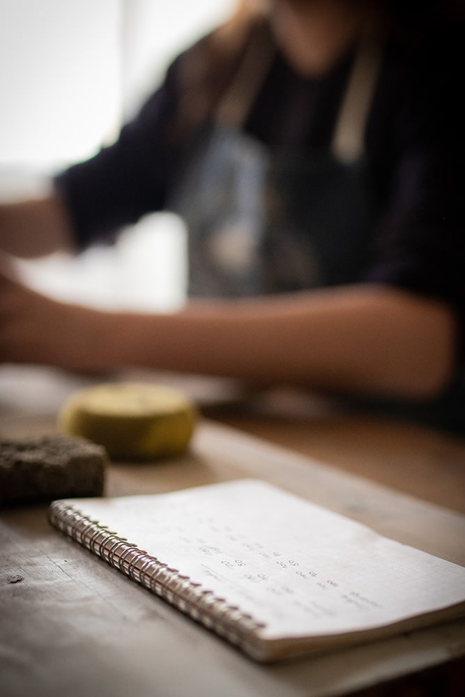 Essai et recherche de recette pour la confection d'un émail artisanal et naturel à base d'ardoise pour la céramique réalisée par Manon Renault, céramiste près de Doué en Anjou et Saumur photographié dans son atelier par Margot Vincent alias Margotine Photographies, photographe près d'Angers dans le maine-et-loire